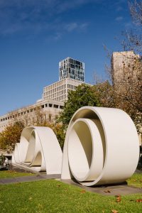 A White scroll sculpture with Skyscrapers in the background