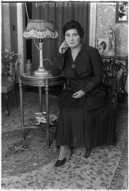 Black and white photograph of a woman wearing a long black dress.