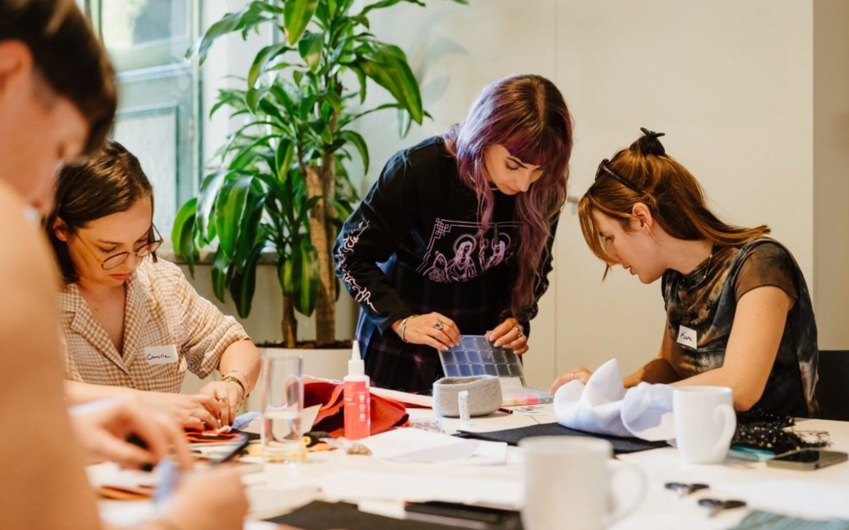 Four individuals leaning over a table.