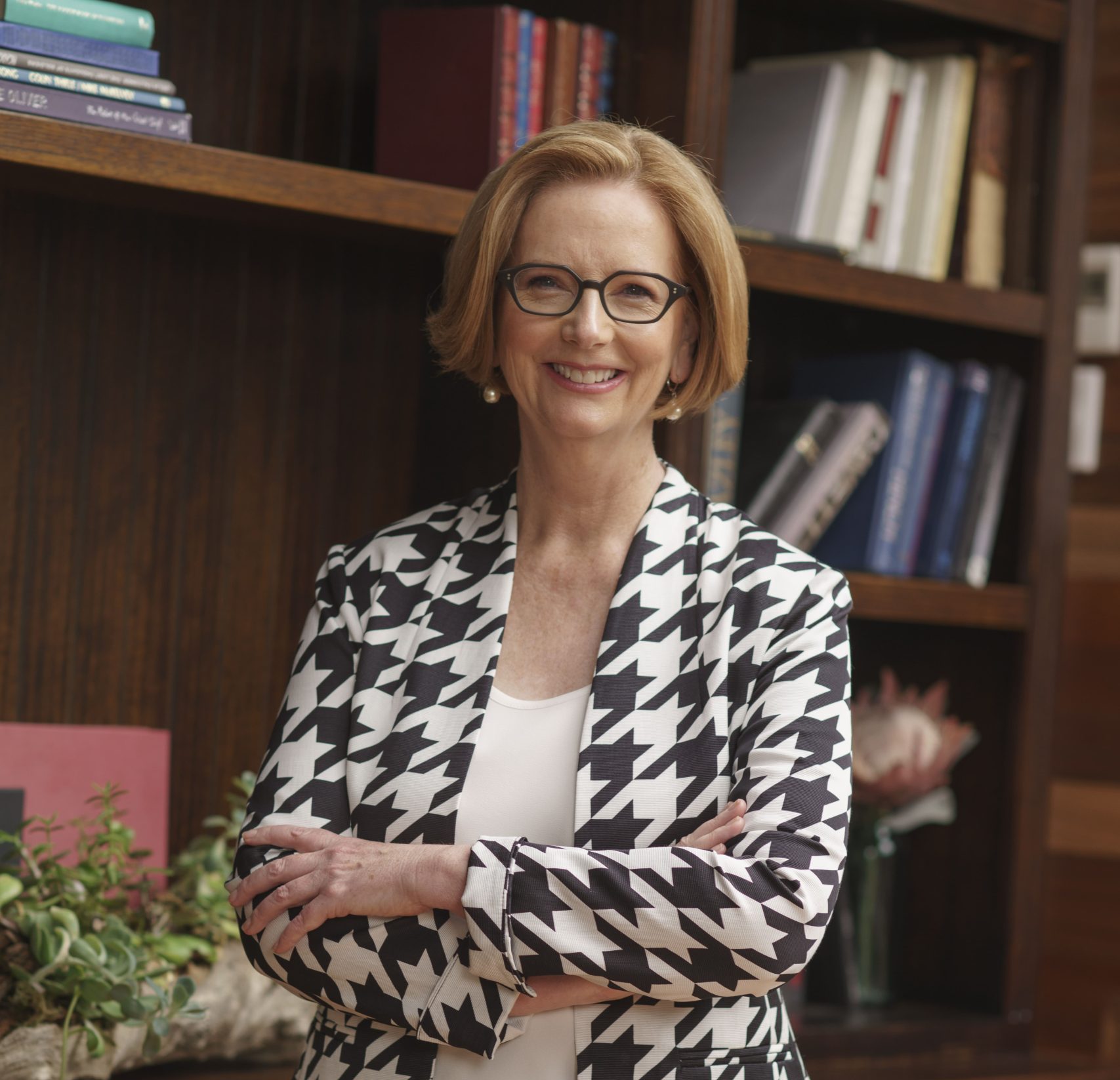 A woman in a blazer smiles at the camera