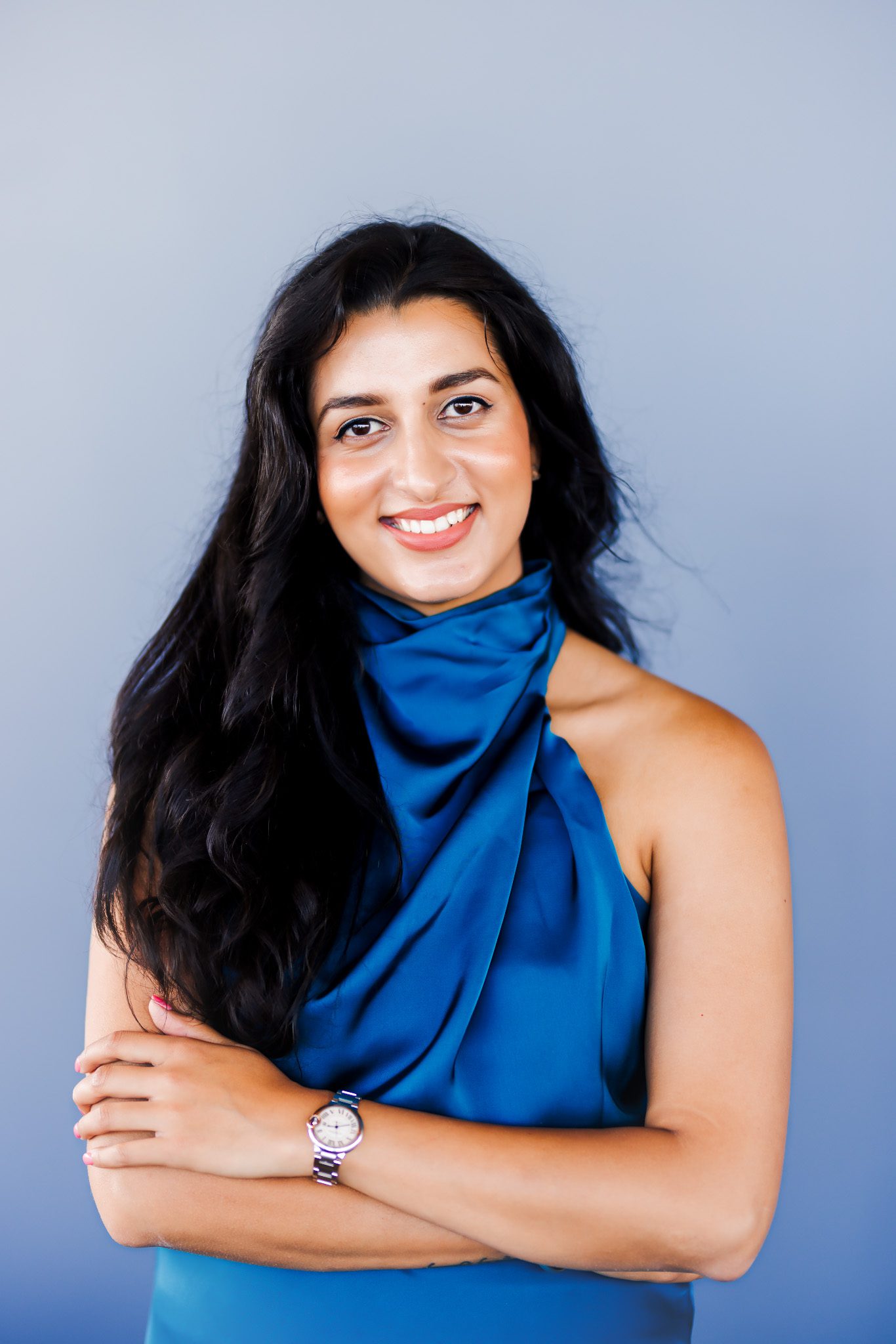 A woman wearing blue smiles to the camera.