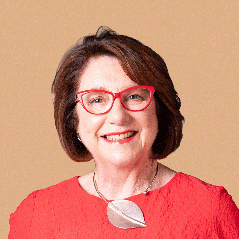 Mary Delahunty wearing red glasses and a red top smiling to camera